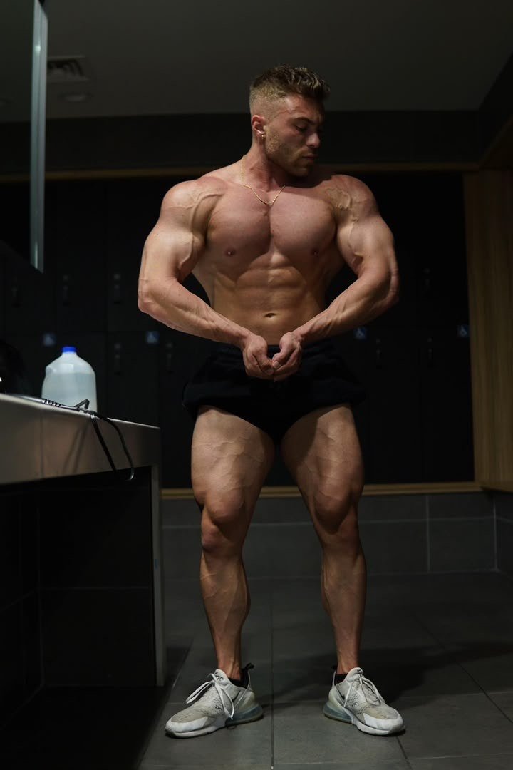 Athlete hitting a front lat spread in a locker room