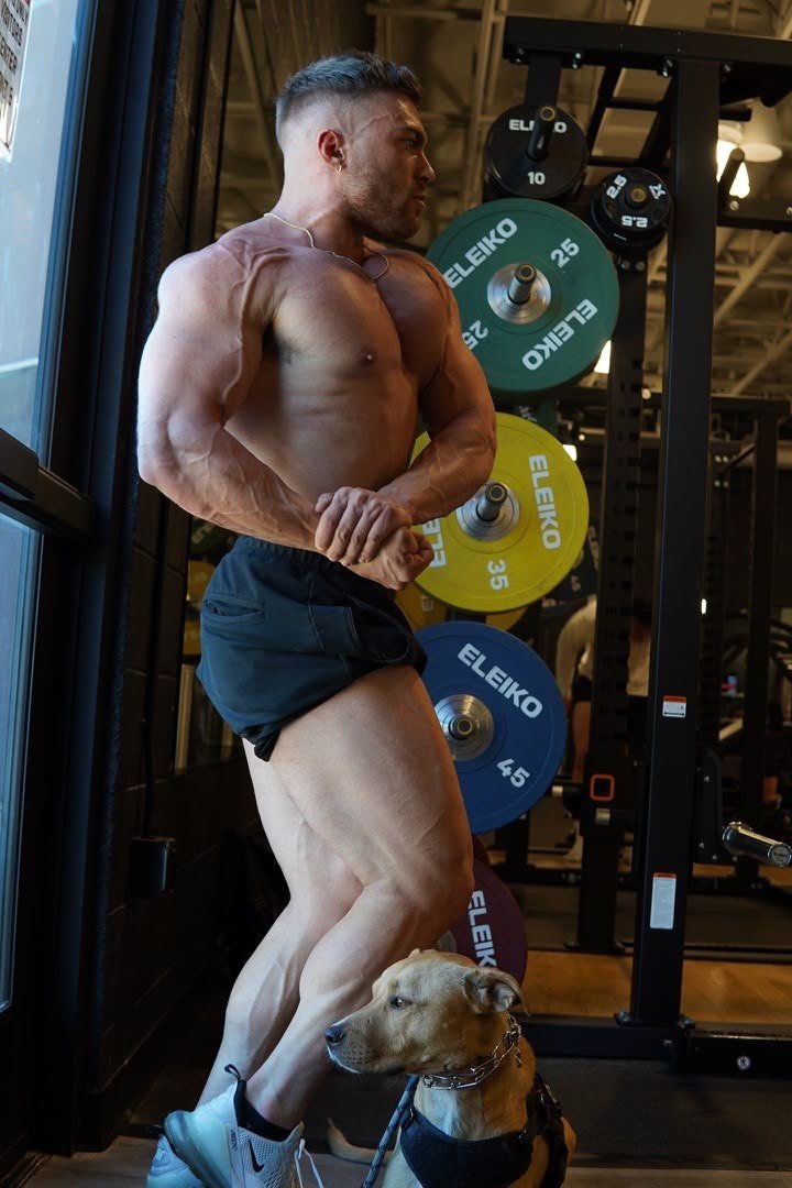 Iron Ascension athlete posing in front of bumper plates
